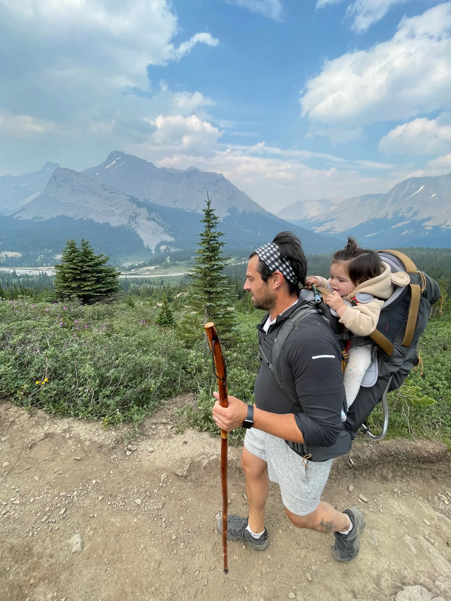 The trail begins through subalpine meadows with mountain views stretching in every direction